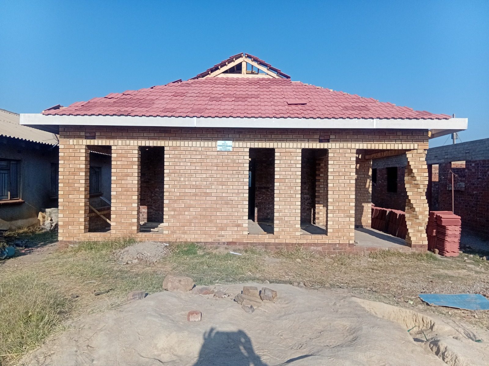 Facebrick house with a red tiled roof and an open gable